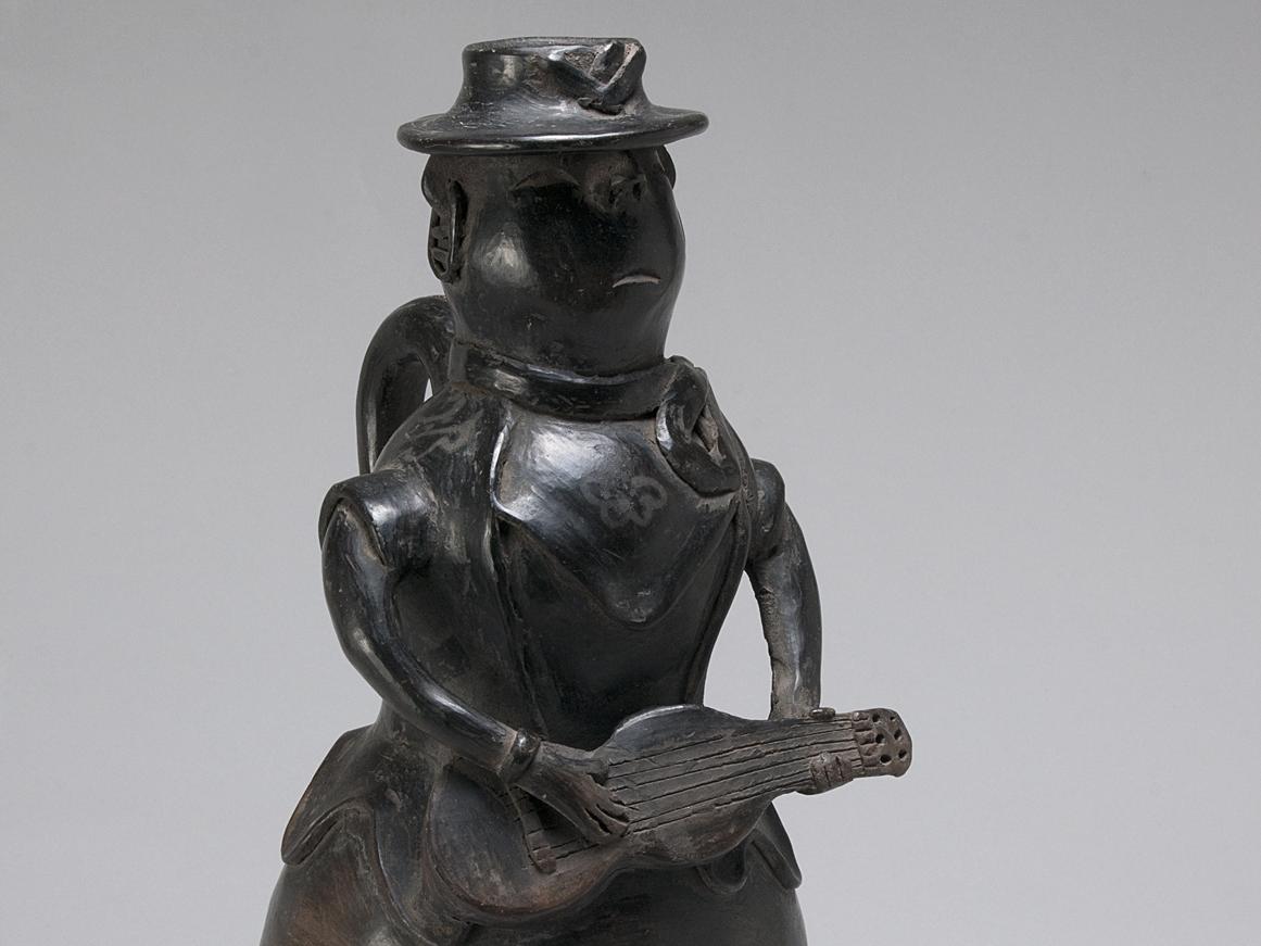 Figura femenina con sombrero y guitarra